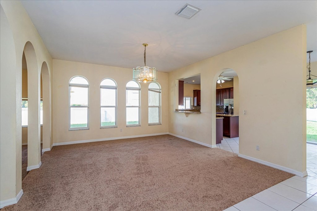 A spacious room with arched windows and a carpeted floor.