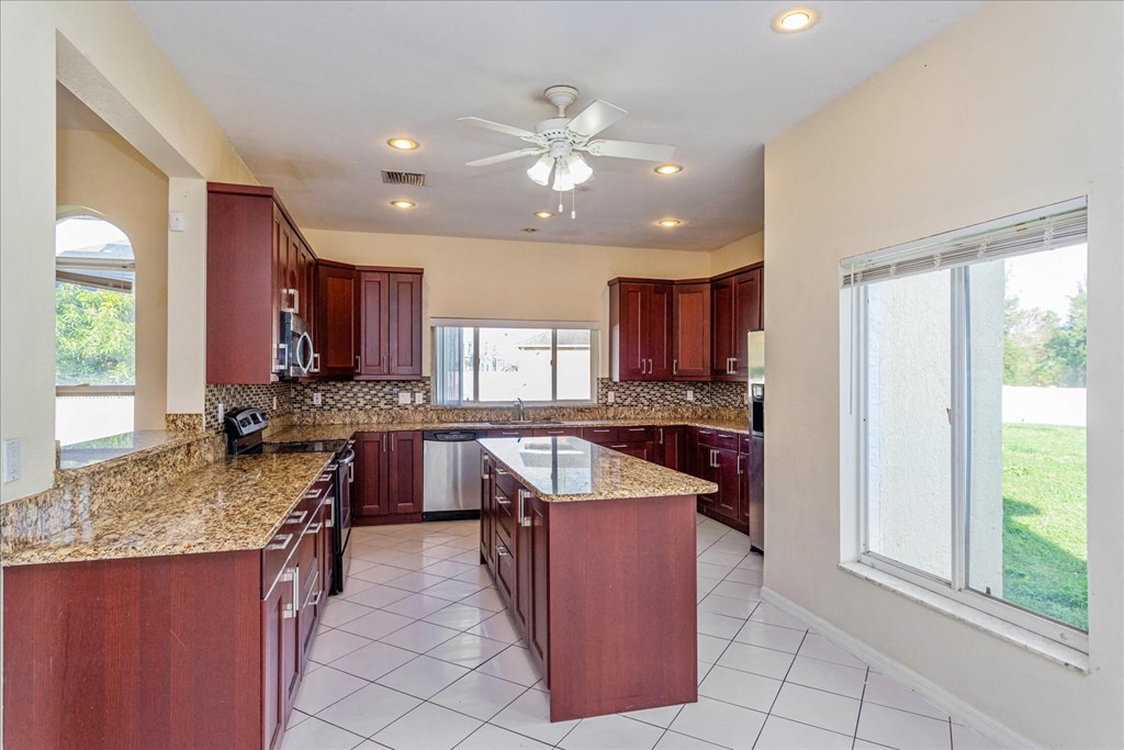 A kitchen with brown cabinets and a granite countertop.