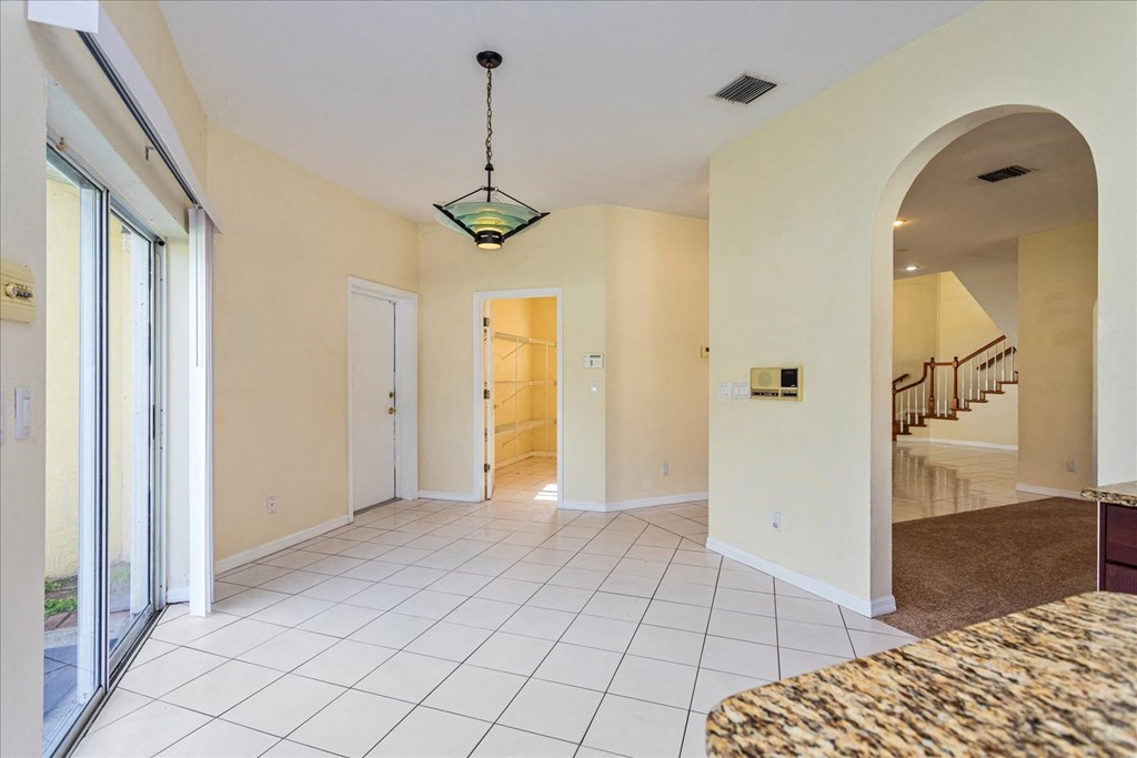 A large, empty room with a marble bench and a hanging light fixture.