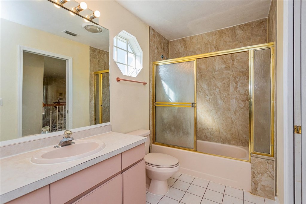 A bathroom with a pink toilet and sink.