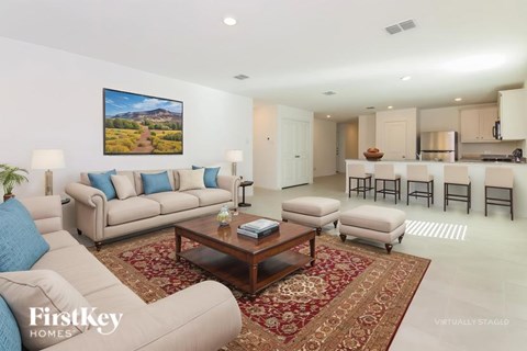 A living room with a couch, a coffee table, and a painting on the wall.