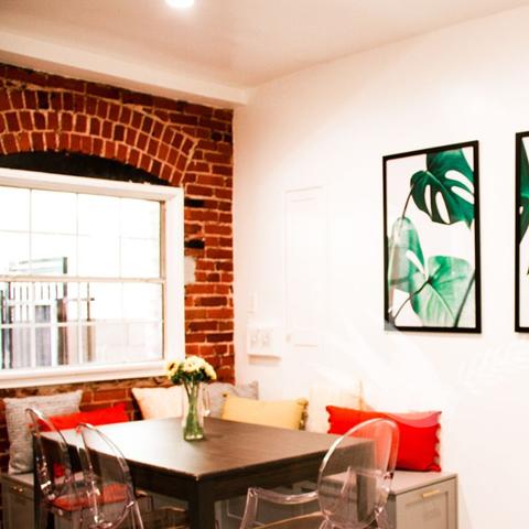 a dining room with a table and chairs and pictures on the wall
