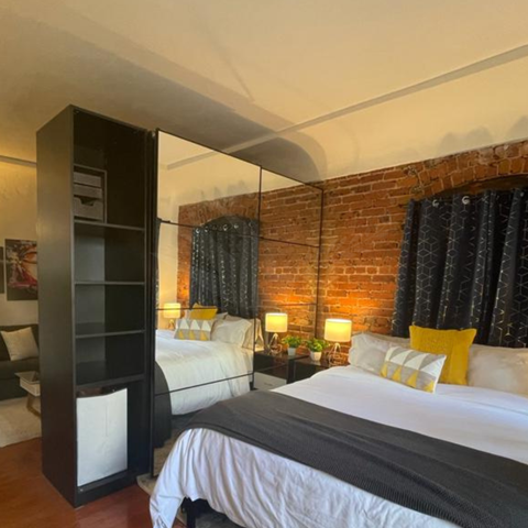 a bedroom with two beds and a large mirror