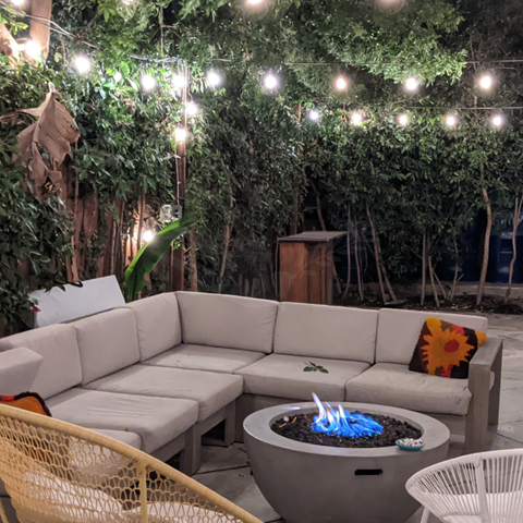 a patio with lights and a fire pit