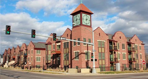 A red brick building with a clock tower and a stoplight.