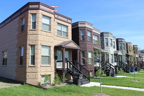 A row of townhouses with a clear blue sky above them.