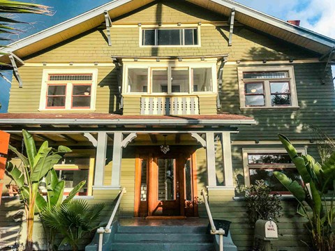 the front of a yellow house with a porch