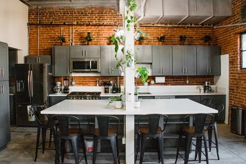 A kitchen with a table and chairs in front of a brick wall.
