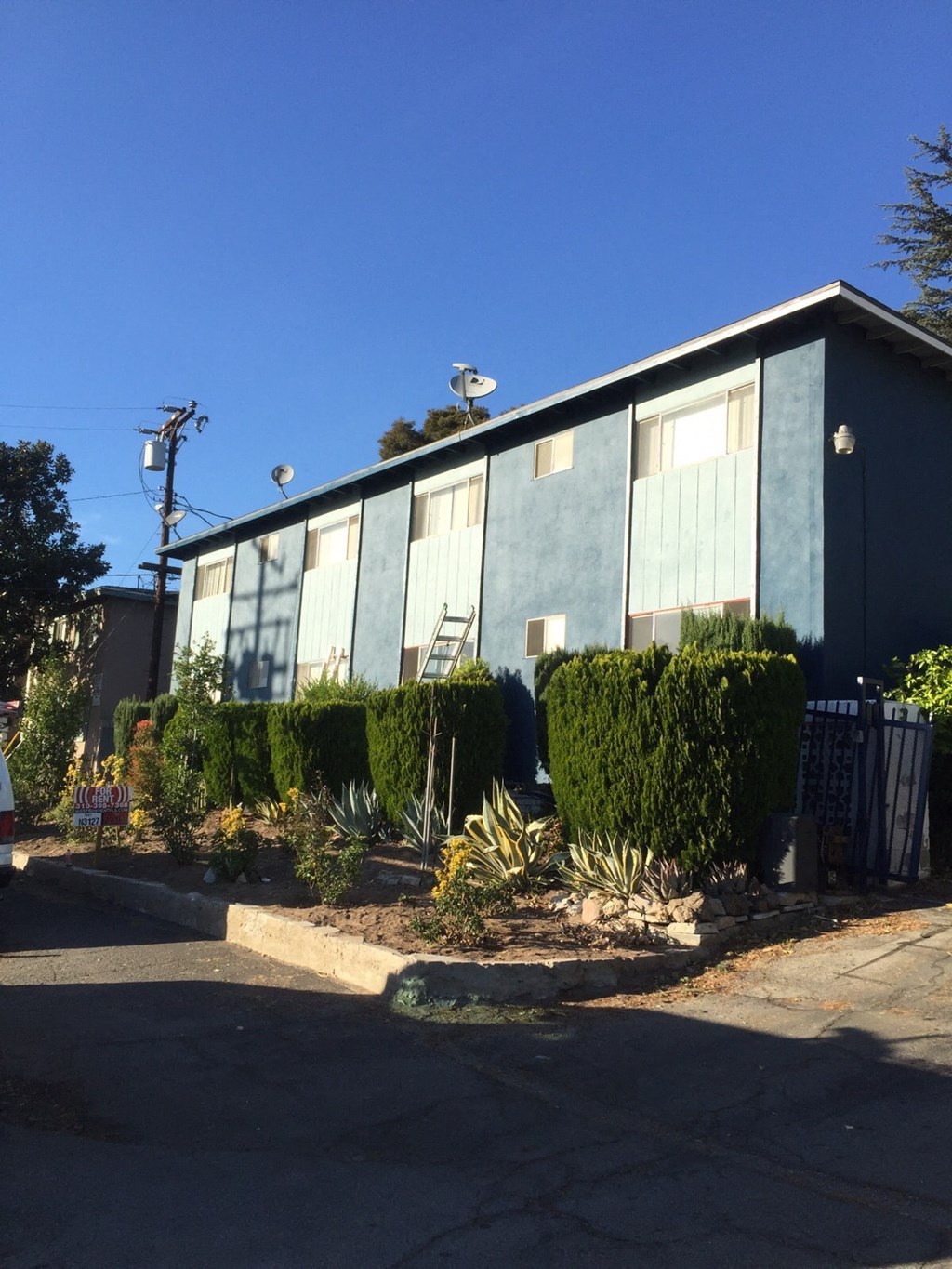 an old blue building with a garden in front of it
