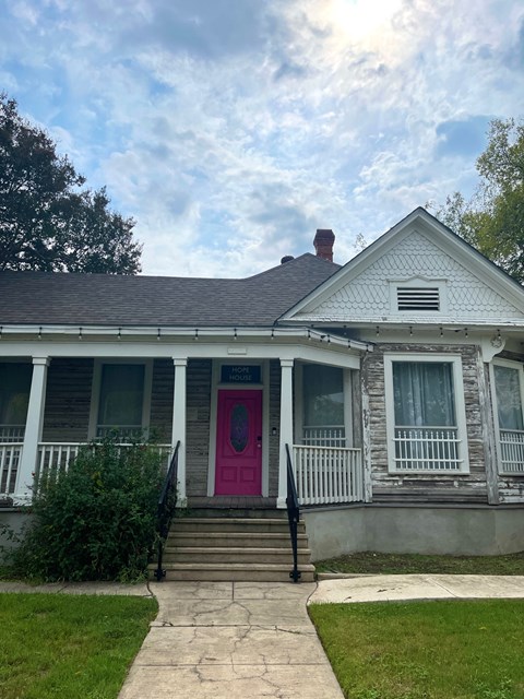 the front of a house with a pink door