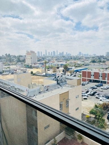 A cityscape with buildings and cars is visible from a high vantage point.