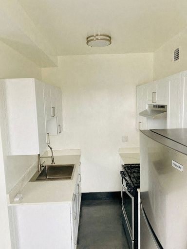 A small kitchen with a sink, stove, and refrigerator.