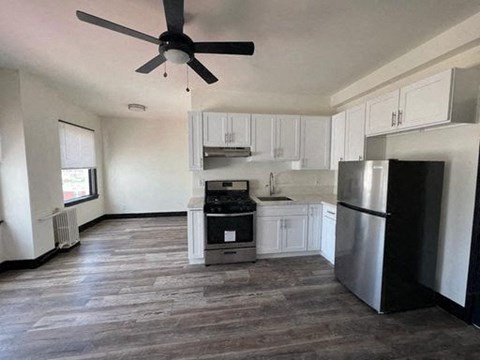 A kitchen with a refrigerator, oven, and microwave.