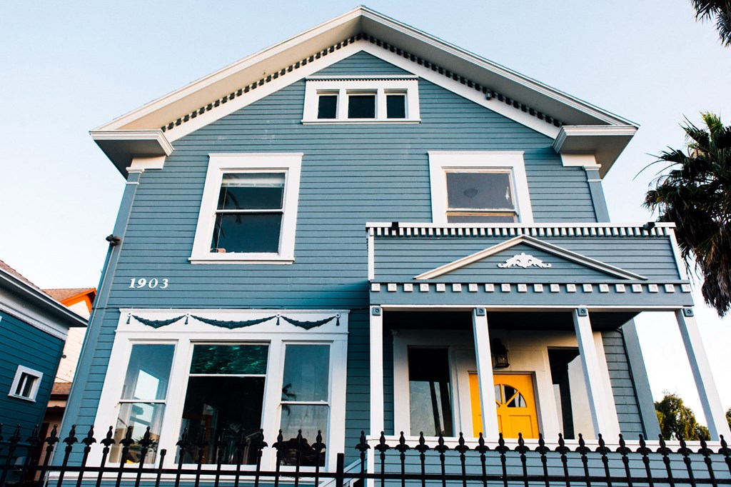 a blue house with a fence in front of it