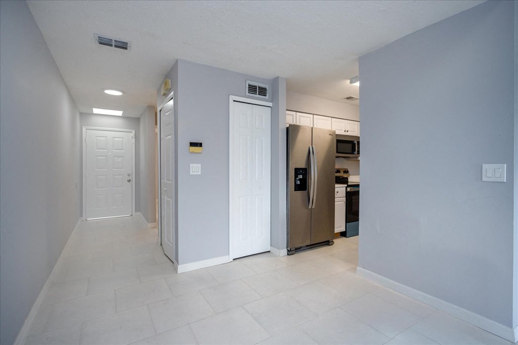 A kitchen with a refrigerator, microwave, and oven.