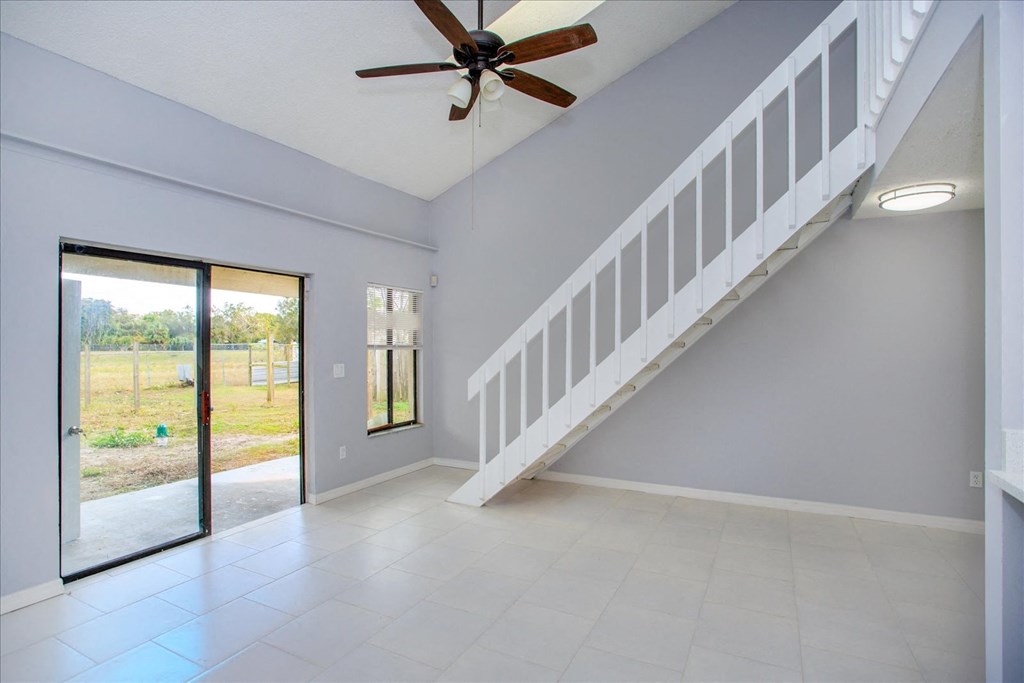 A room with a staircase and a ceiling fan.