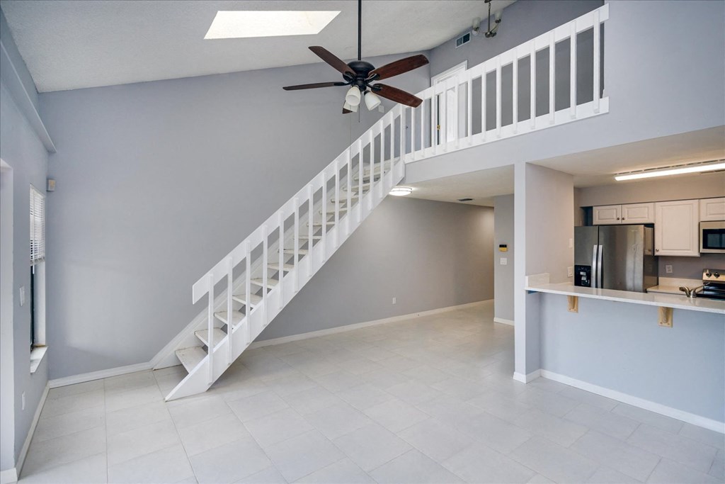 A white staircase with a fan on the ceiling.