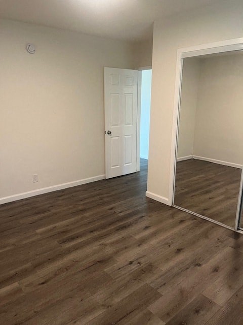 A room with a white door and a wooden floor.