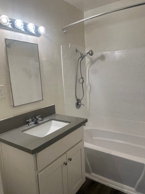 A bathroom with a sink, mirror, and shower.