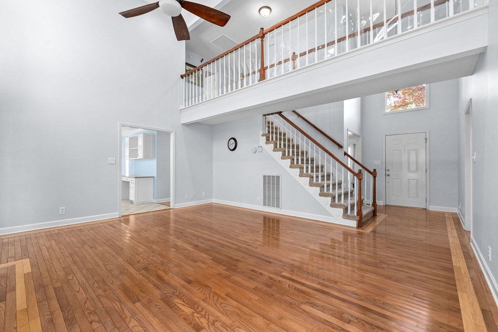 a living room with a staircase and a hard wood floor