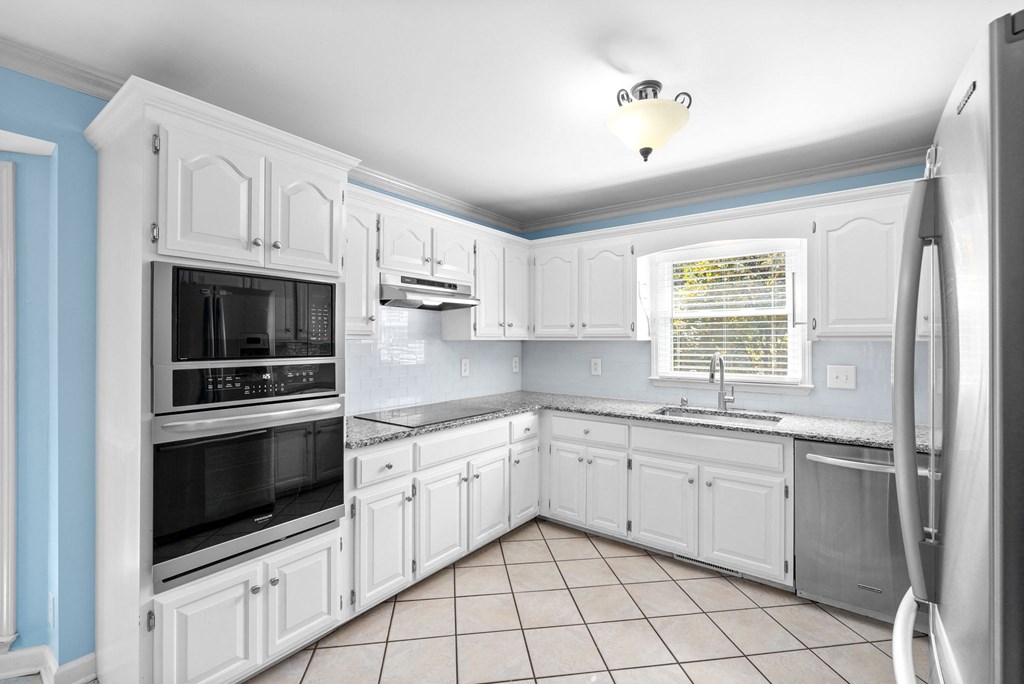 a kitchen with white cabinets and stainless steel appliances