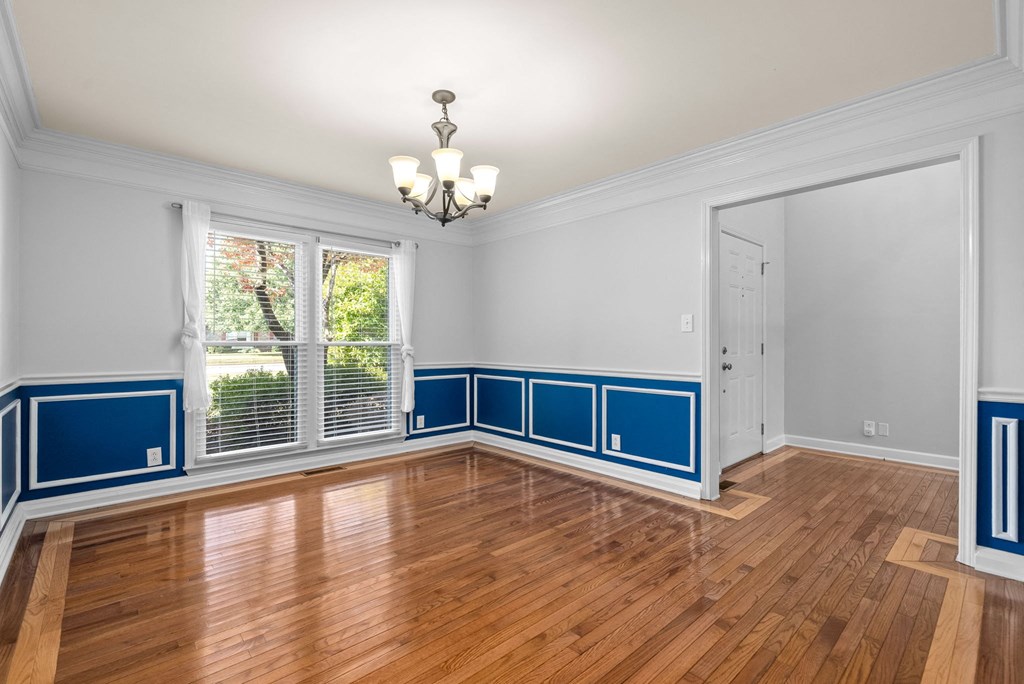 an empty living room with blue and white walls and a window