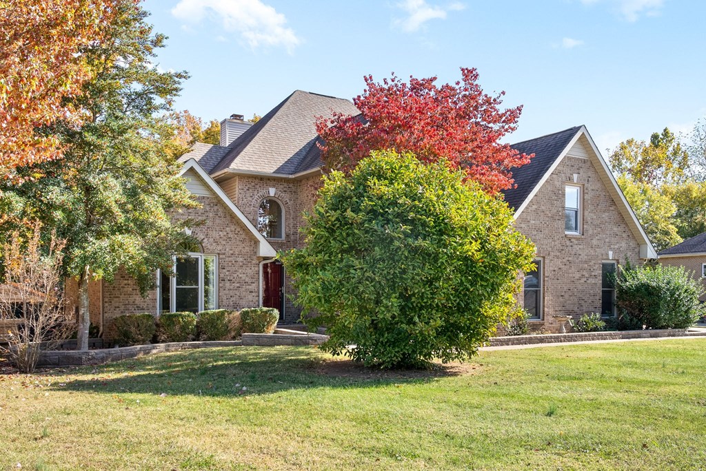 a house with a lawn and a tree in front of it
