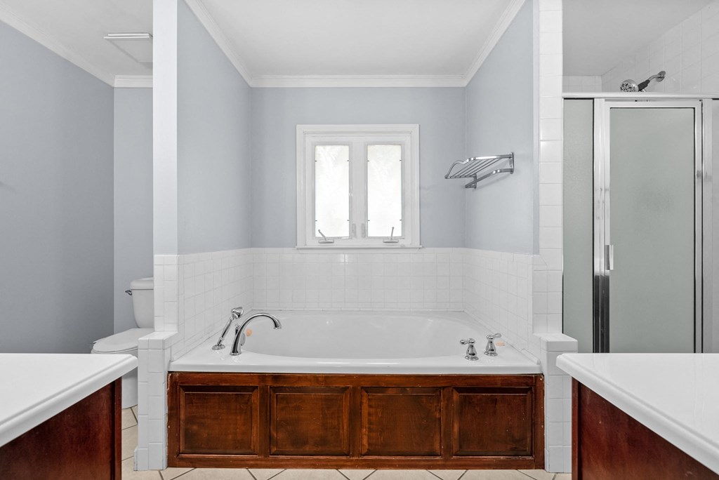 a bathroom with a tub and a shower and a sink