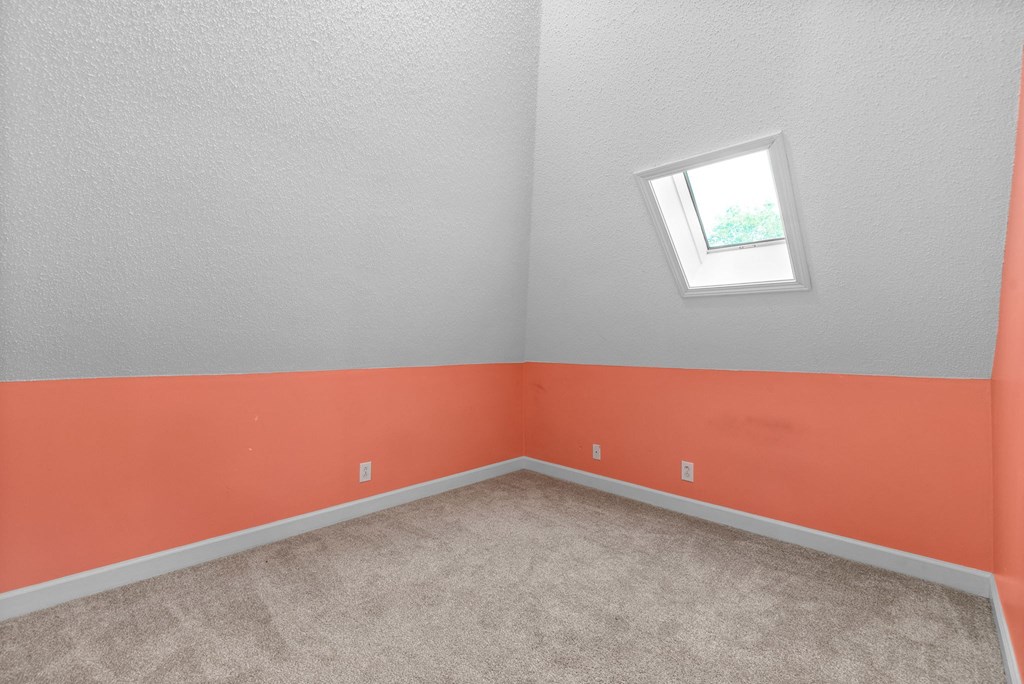 an empty room with orange and gray walls and a window