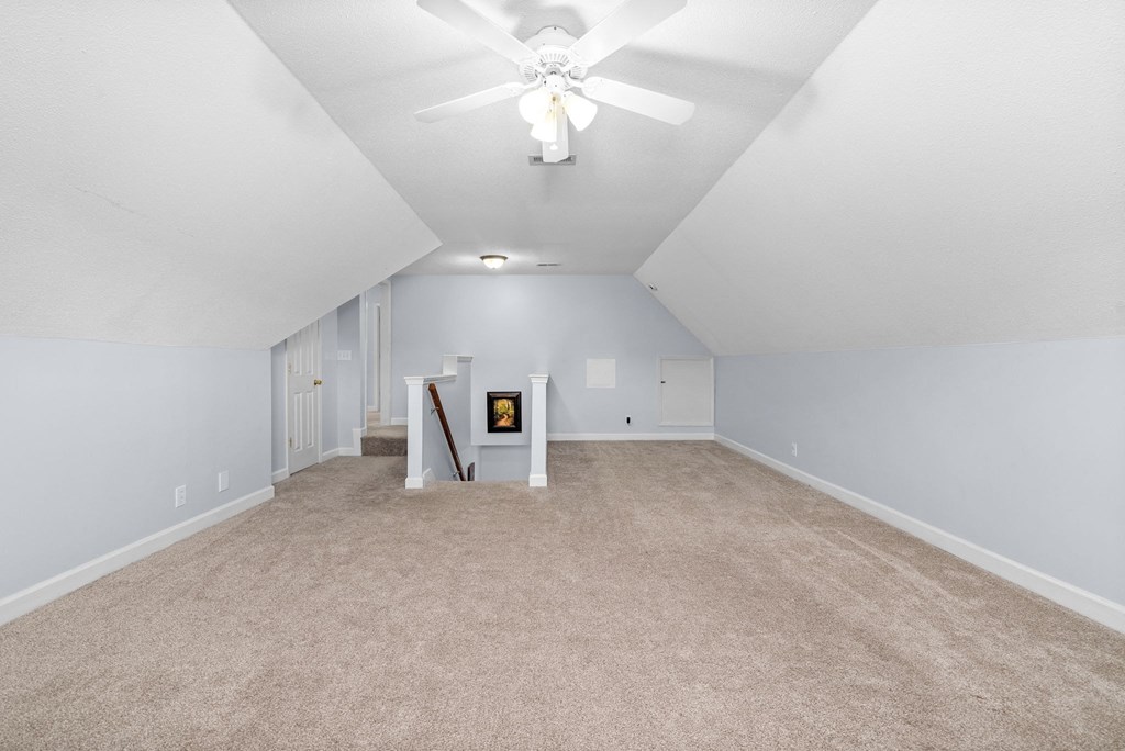 the living room with carpet and a ceiling fan