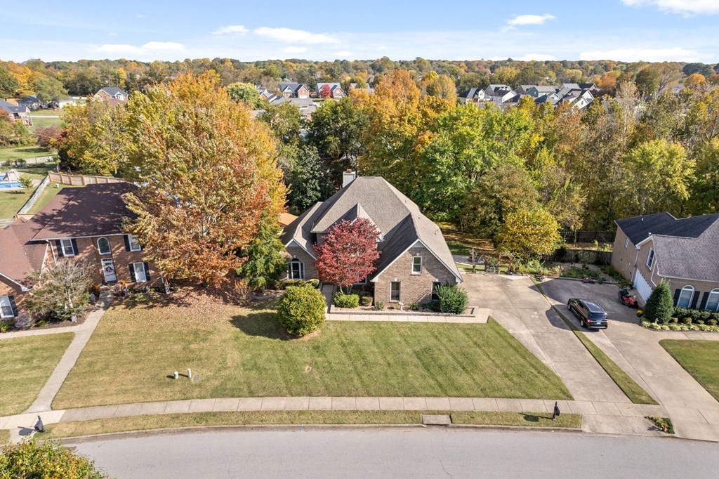 an aerial view of a house in a neighborhood with trees
