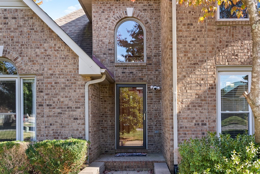 the front of a brick house with a glass door