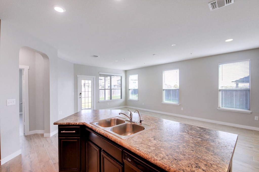 an empty kitchen with a sink and a counter top