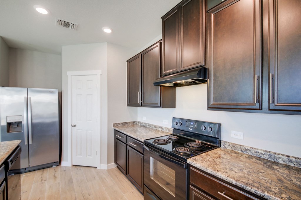 a kitchen with wooden cabinets and stainless steel appliances