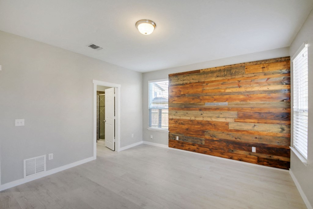 an empty living room with a reclaimed wood wall