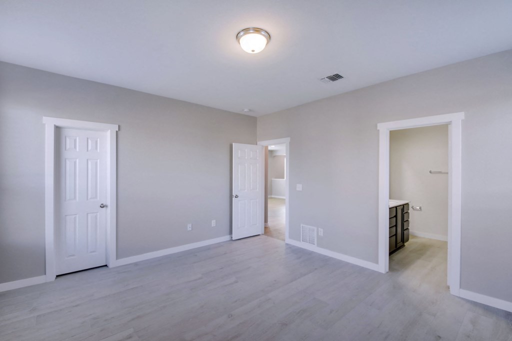 the living room of a new home with white walls and wood flooring