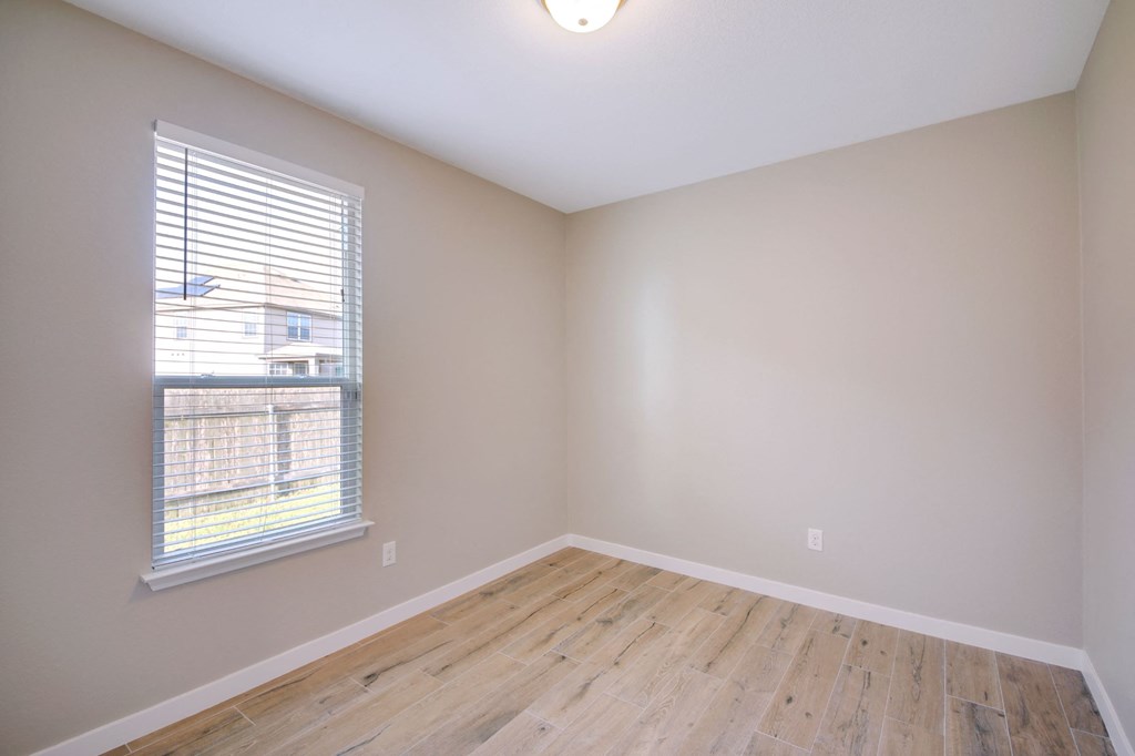 an empty room with wood floors and a window