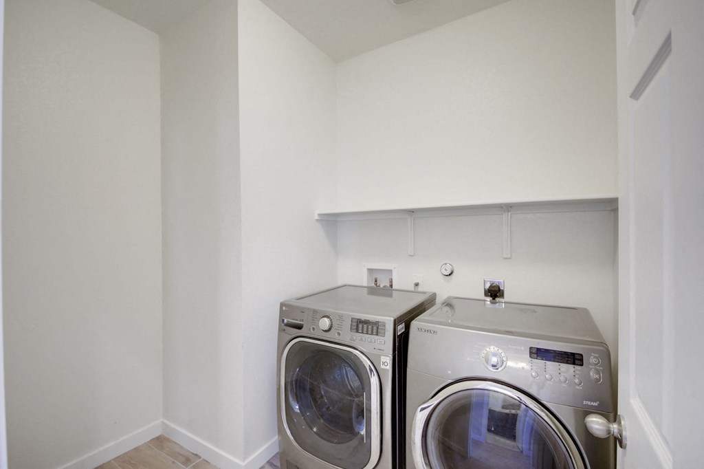 a washer and dryer in a laundry room with white walls