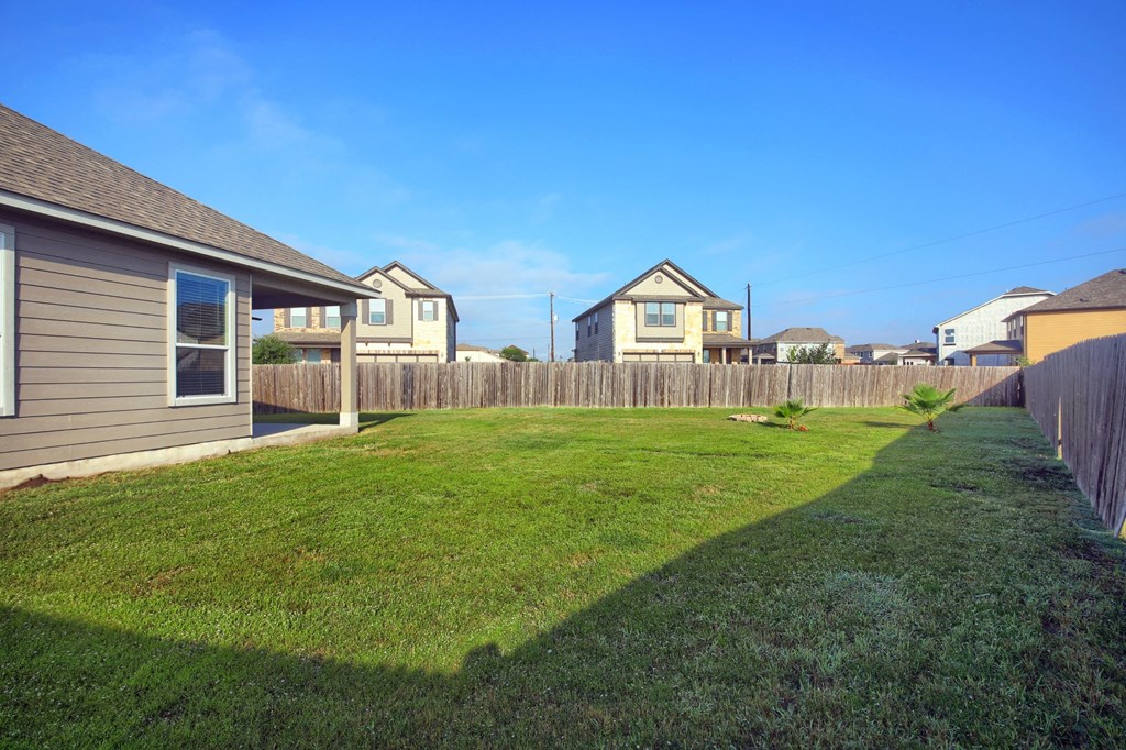 the backyard of a house with a yard and a fence