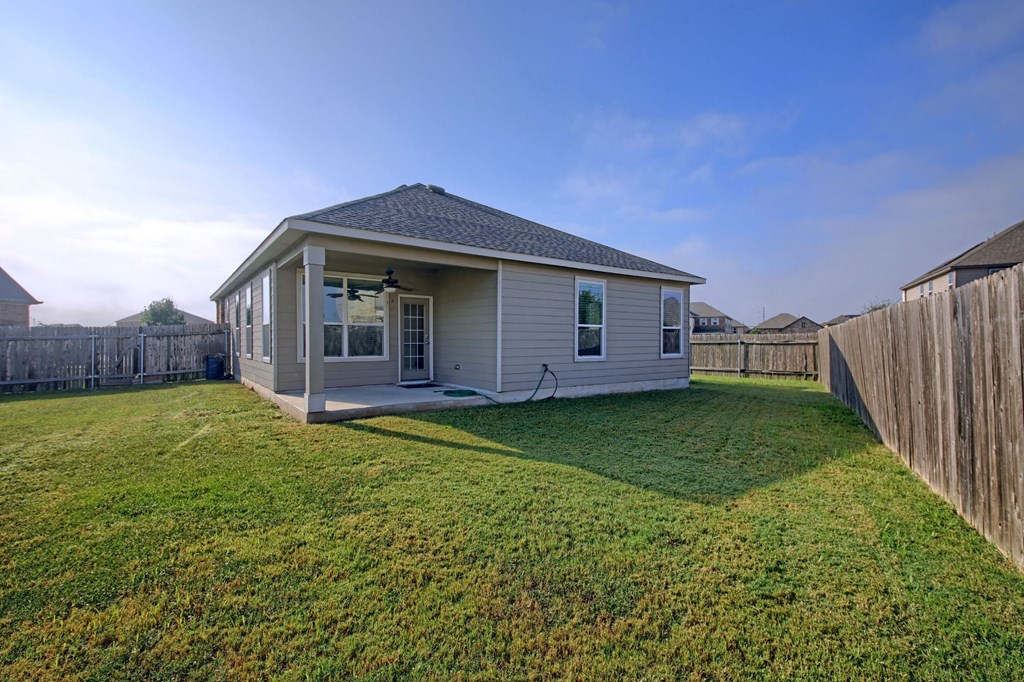 a small house with a backyard and a fence