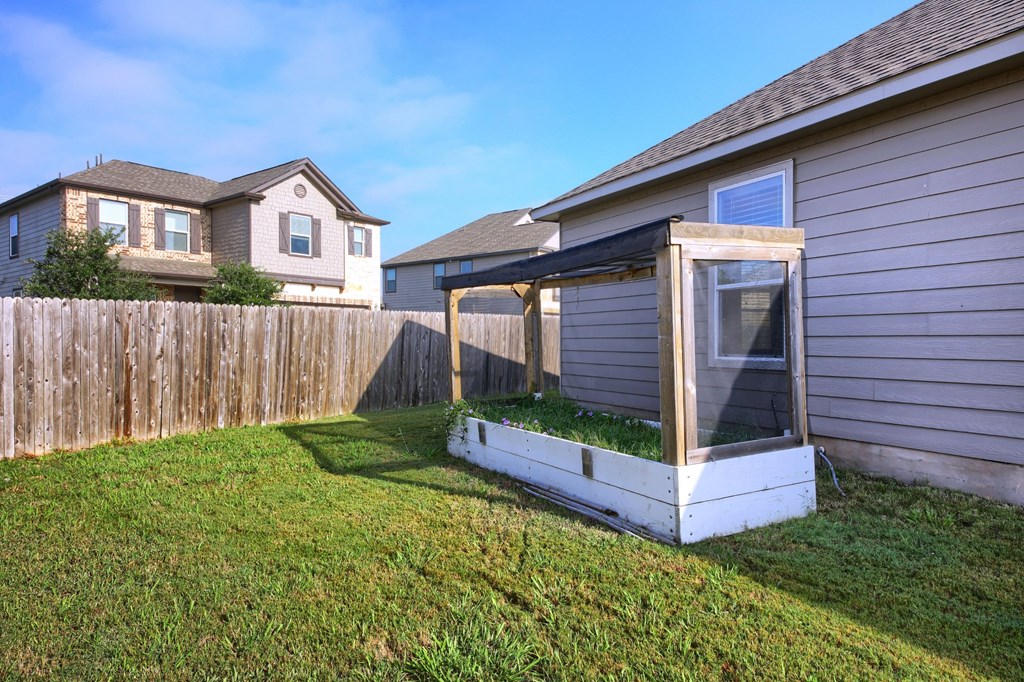 a backyard with a fence and a patio with a gazebo