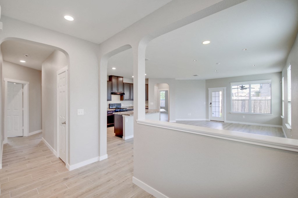 a renovated kitchen and living room with white walls and wood floors