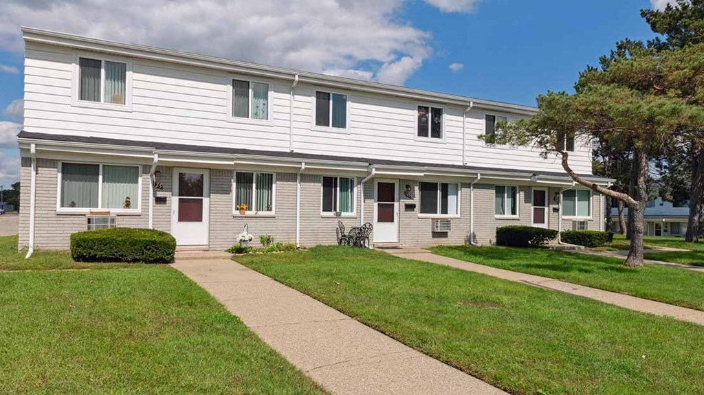 a white building with a sidewalk in front of it