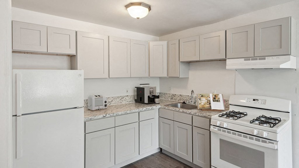 a kitchen with white appliances and white cabinets
