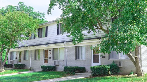 a white house with a tree in front of it