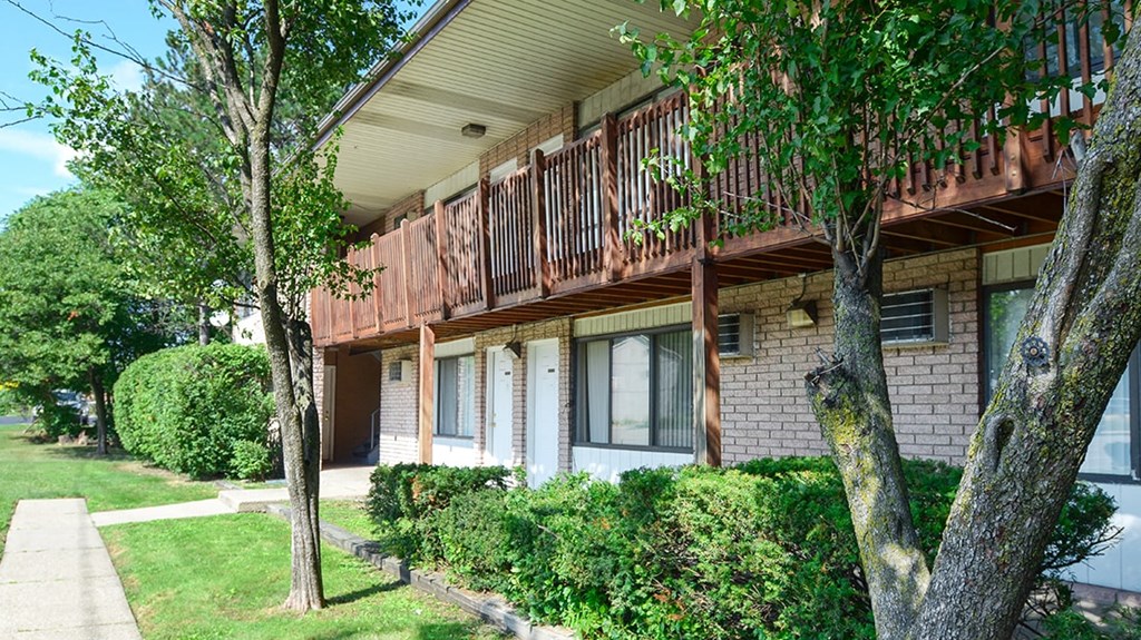 a house with a porch and a tree in front of it