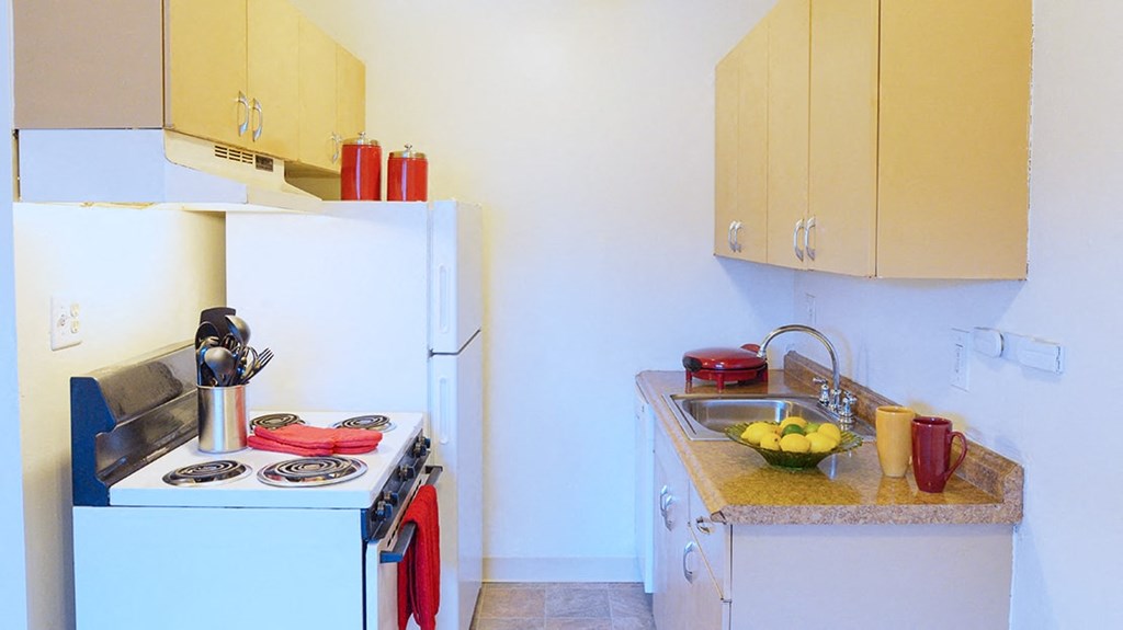 a small kitchen with a stove refrigerator and sink
