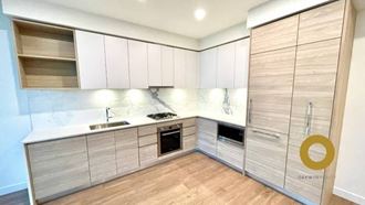 a kitchen with white cabinets and a wooden floor