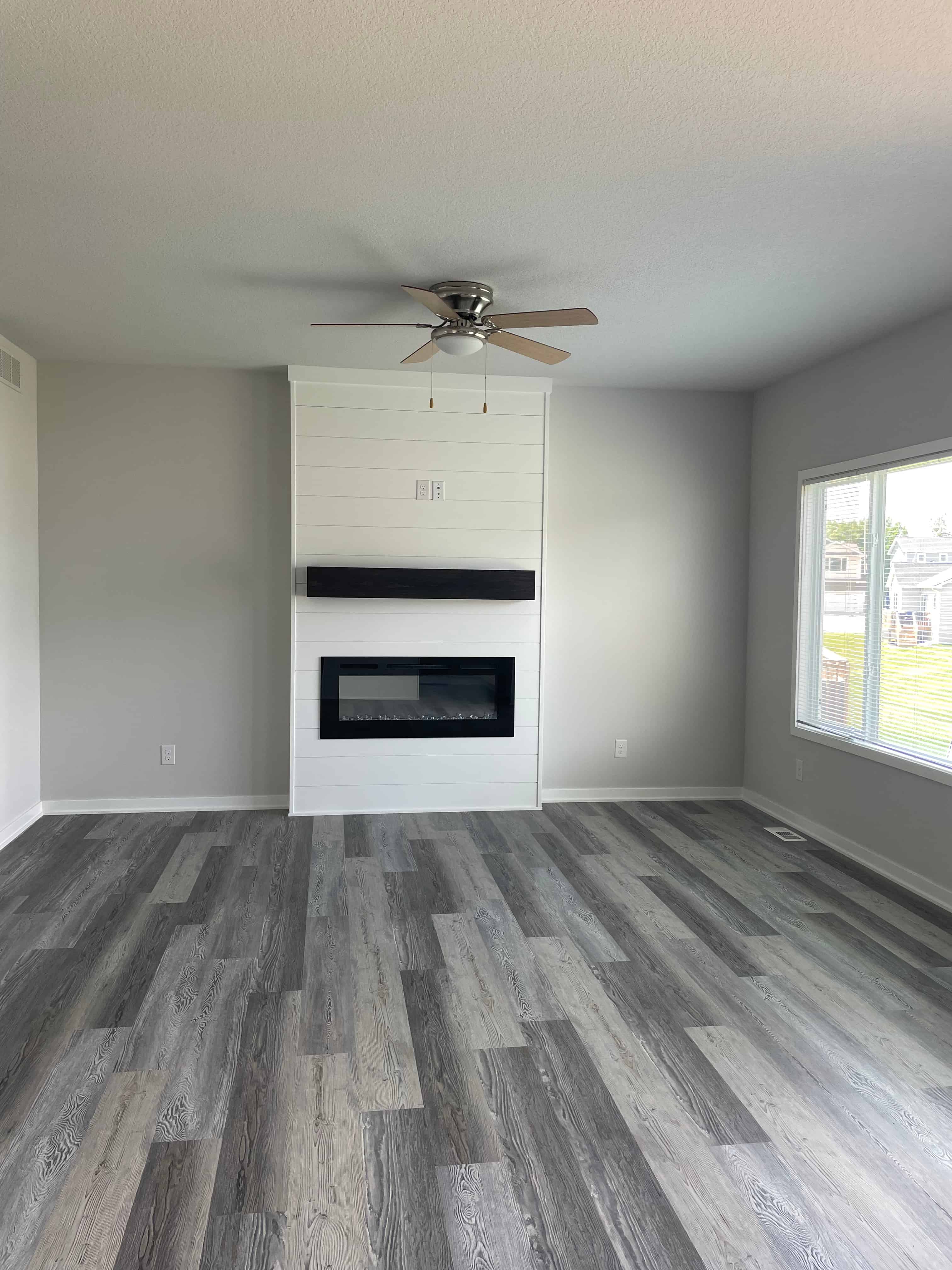 a living room with a fireplace and a ceiling fan