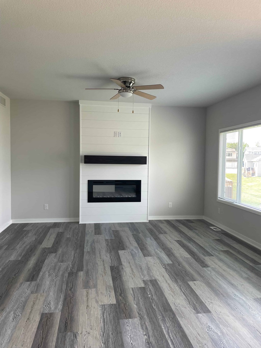 a living room with a fireplace and a ceiling fan